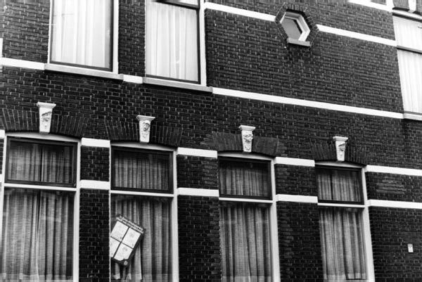 gevel met kopjes en zeshoekig raam adres onbekend