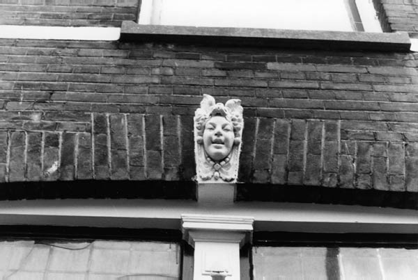 ornament boven raam met kopje en baksteen adres onbekend